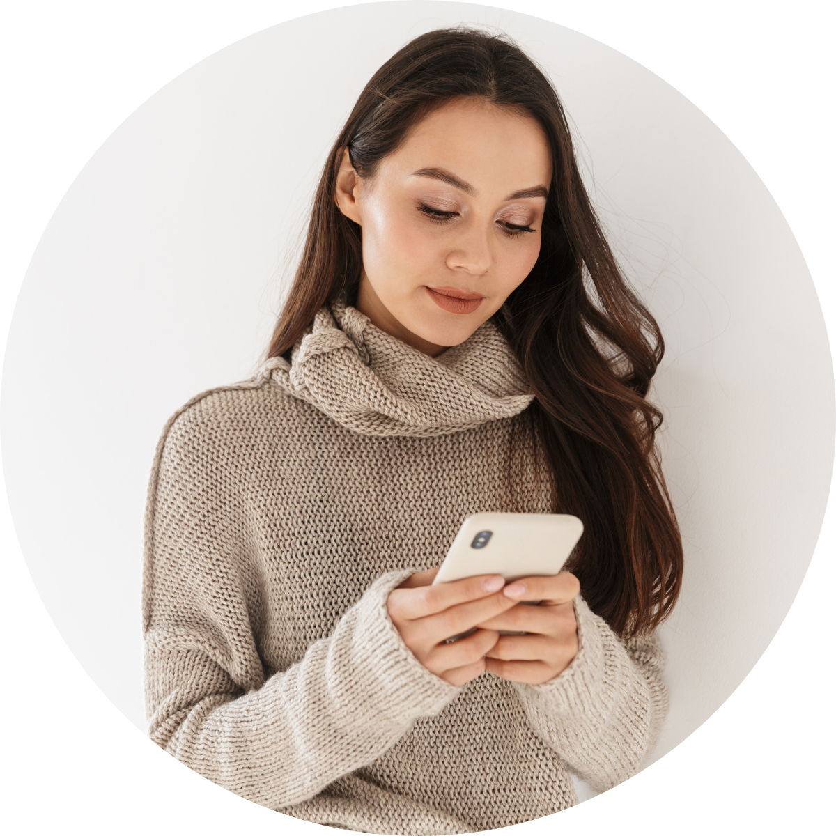 Young business woman in a cozy sweater looking at her smartphone.